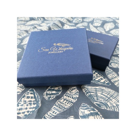 Dark blue jewellery box wrapping with Sea Whispers logo in gold